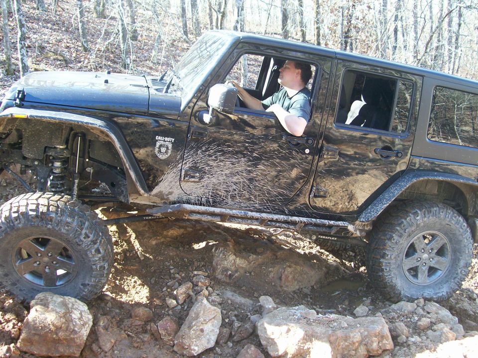 Black Jeep Wrangler with Call of Duty decal on the door, driving over rocks