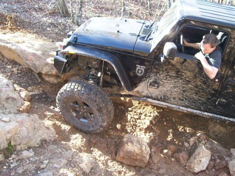 2007 Jeep Wrangler - A black Jeep Wrangler tackles a challenging off-road course, with a driver visible inside and a Call of Duty decal on the door.