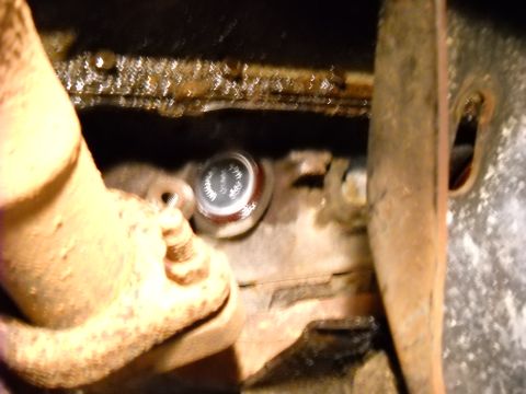 1993 Ford C-150 (Centurion Conversions) - A freeze plug is visible on the engine block, surrounded by dirt and corrosion.