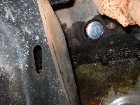 1993 Ford C-150 (Centurion Conversions) - A freeze plug is visible in this close-up of an engine block, showing signs of oil leakage.