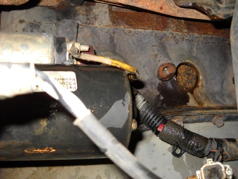 1993 Ford C-150 (Centurion Conversions) - Close-up view of a starter motor and associated wiring, with visible text on the motor housing.