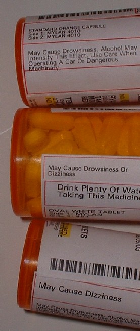 1986 Ford Bronco - Three orange prescription pill bottles are stacked, showing various medication labels and contents.