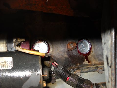 1993 Ford C-150 (Centurion Conversions) - Close-up of engine block showing freeze plugs and associated engine components.