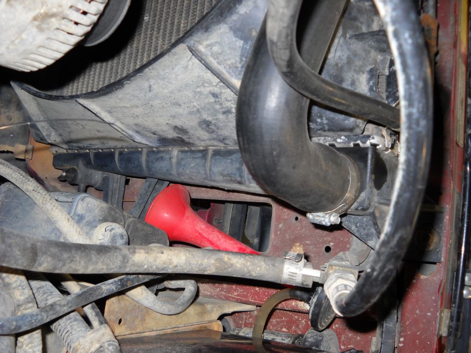 Red funnel in engine bay near radiator and hoses