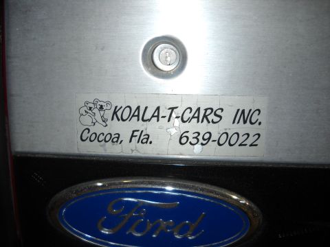 1993 Ford C-150 (Centurion Conversions) - A close-up shows a Ford emblem and a sticker for Koala-T-Cars Inc. from Cocoa, Florida.