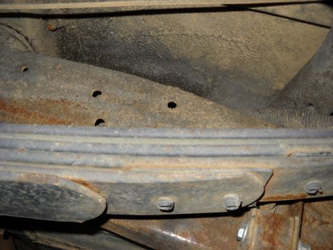 1993 Ford C-150 (Centurion Conversions) - Undercarriage view showing the leaf spring and frame of a vehicle, with visible rust.
