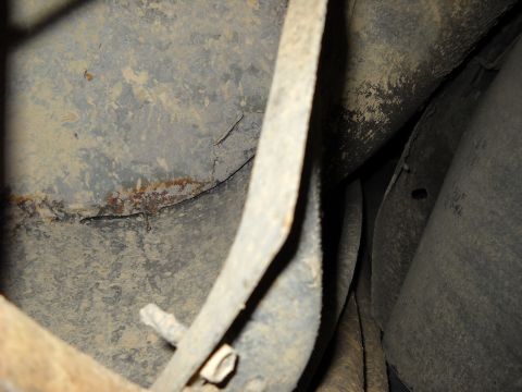 1993 Ford C-150 (Centurion Conversions) - Close-up view of the undercarriage of a vehicle, revealing aged metal and accumulated grime.