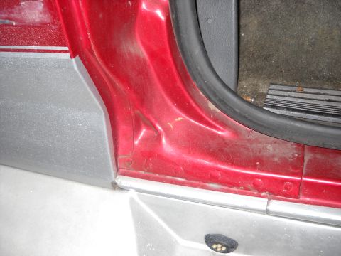 1993 Ford C-150 (Centurion Conversions) - Close-up of a vehicle's interior door frame, showing damage and wear.