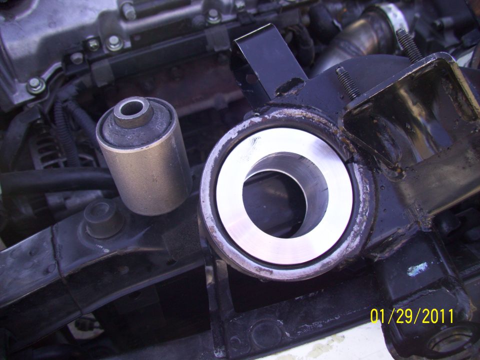 Engine bay with suspension bushings and metal bracket