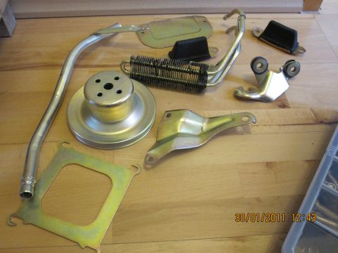 1973 Ford Ranchero - Various metal automotive components are displayed on a wooden surface, likely for a restoration project.