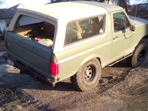 1989 Ford Bronco - Rear view of a 1989 Ford Bronco with a removable soft top, parked outdoors.