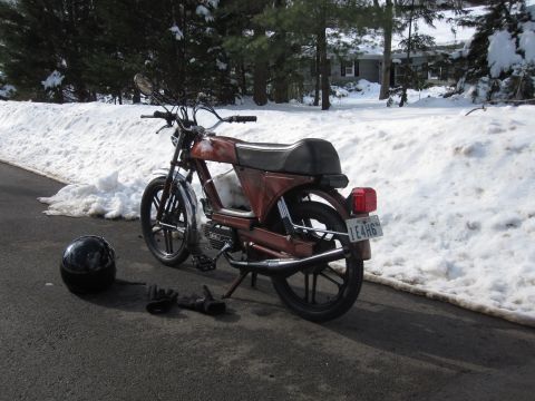 1981 Garelli Rally Sport - A red moped sits on a paved surface next to snow-covered ground, viewed from the rear.