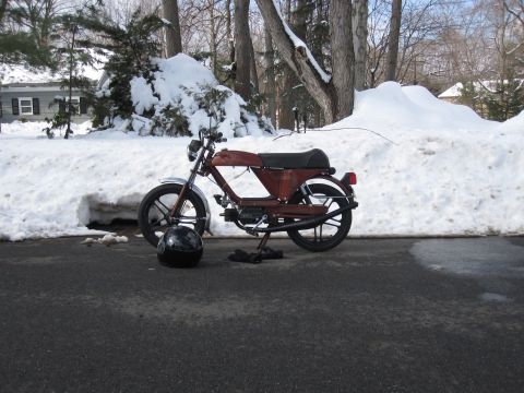 1981 Garelli Rally Sport - A moped sits parked on a driveway surrounded by snow, with a helmet and gloves nearby.
