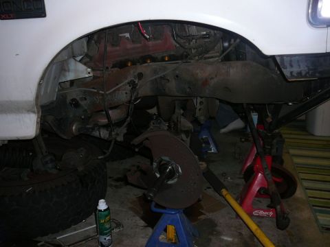 1988 Ford Bronco - Front suspension work on a 1988 Ford Bronco, showing removed wheel and brake components.