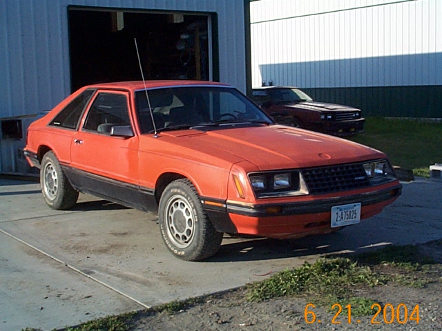 Orange 1983 Mercury Capri coupe with black trim and a Minnesota license plate
