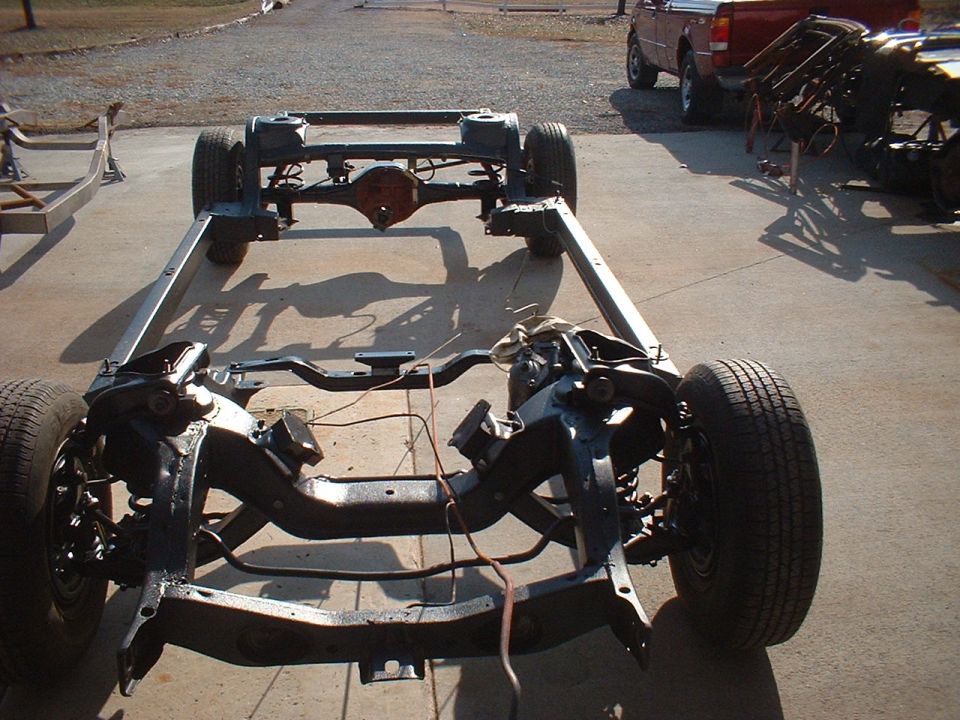 Car frame with wheels and suspension components, viewed from above