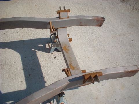 1969 Ford Torino - A vehicle's frame is supported by jack stands on a concrete surface, revealing its structural components.