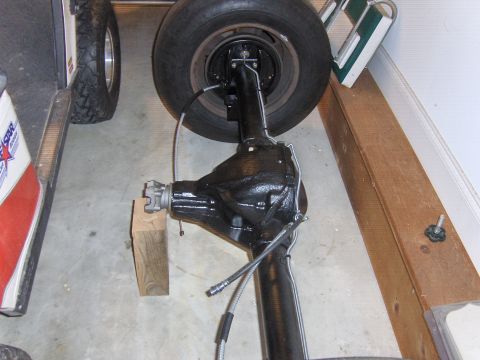 1979 Chevrolet Camaro - A rear axle assembly is shown, complete with a tire and brake components, resting on a concrete floor.