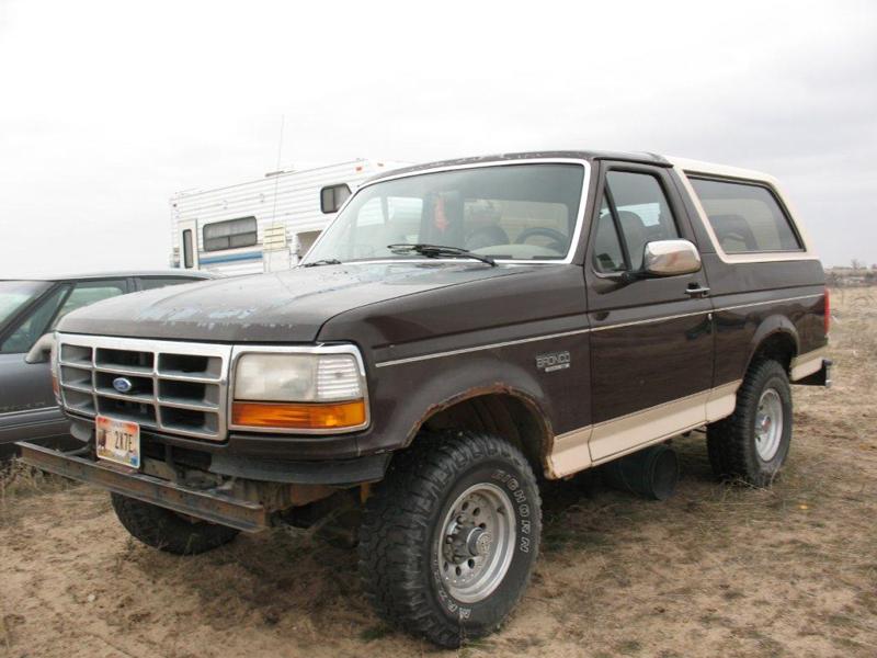 Brown 1992 Ford Bronco with tan lower trim and a white roof, viewed from the front-right