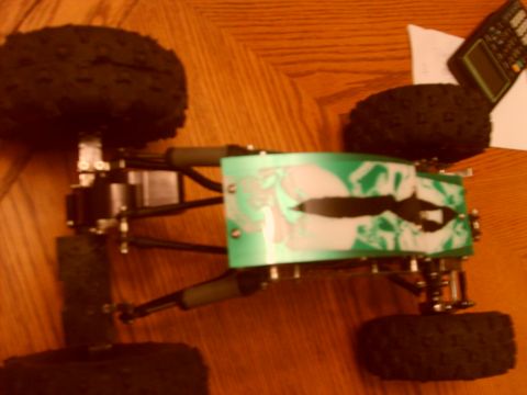 1989 Ford Bronco - A remote control car chassis with visible suspension and a green decorative panel is shown from a side angle.