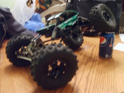 1989 Ford Bronco - This remote control rock crawler toy has large, knobby tires and a green body. A Pepsi can is visible nearby.