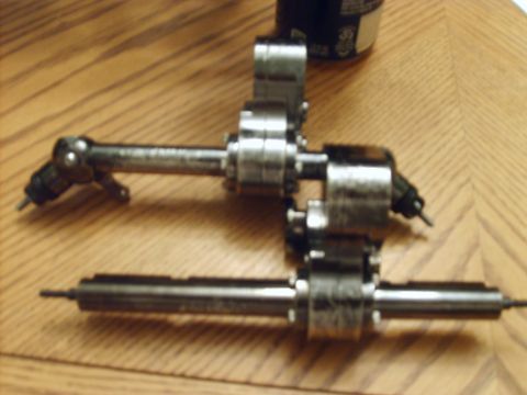 1989 Ford Bronco - Two metal fuel injectors are shown on a wooden table.