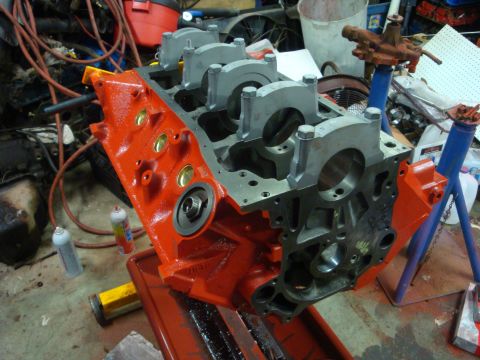 1989 Ford Bronco - Engine block on a stand in a workshop, with tools and parts in the background.