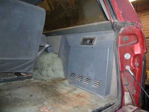 1993 Ford C-150 (Centurion Conversions) - Interior view of a vehicle, focusing on the rear passenger side panel and seat.