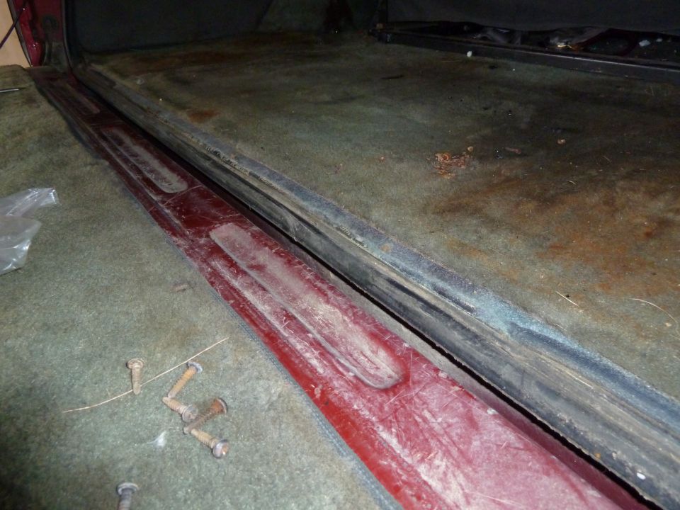 Interior door sill with red trim and green carpet