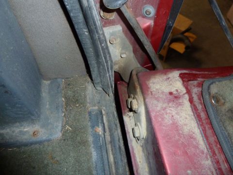 1993 Ford C-150 (Centurion Conversions) - The interior of a vehicle shows a close-up view of the door hinge mechanism and surrounding trim panels.
