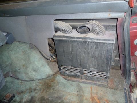 1993 Ford C-150 (Centurion Conversions) - The interior of a vehicle displays a black plastic unit with vents and two flexible hoses.