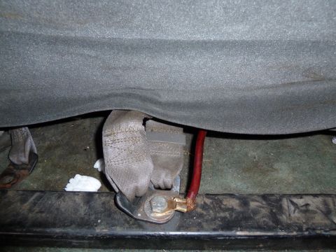 1993 Ford C-150 (Centurion Conversions) - The underside of a vehicle seat shows a seatbelt anchor and some electrical wiring.