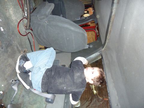 1993 Ford C-150 (Centurion Conversions) - A child sits in the interior of a vehicle, with seats and wiring visible.