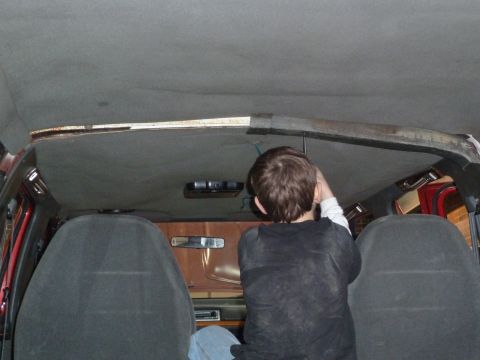 1993 Ford C-150 (Centurion Conversions) - A person works on the headliner inside a vehicle's interior.