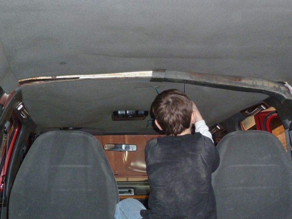 Interior view of a vehicle with a person working on the headliner