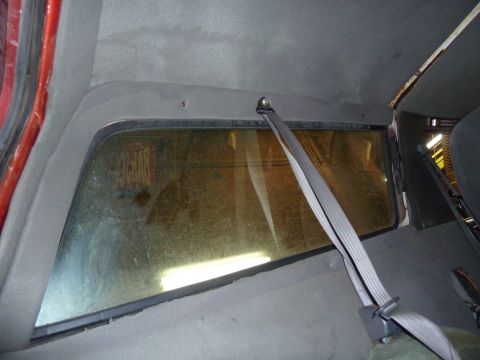1993 Ford C-150 (Centurion Conversions) - Interior view of a vehicle, focusing on the rear window and a seatbelt mechanism.