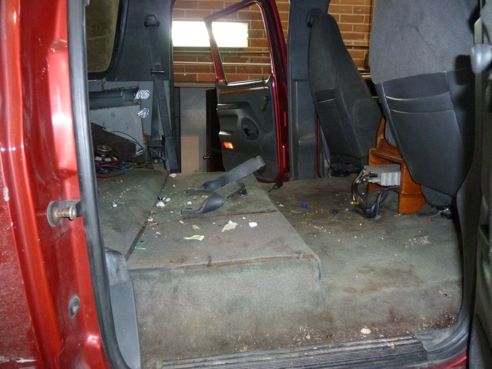 Interior of a red van with seats removed and carpeted floor