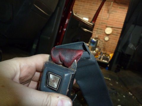1993 Ford C-150 (Centurion Conversions) - Close-up of a vehicle's seatbelt mechanism, showing the buckle and part of the strap.