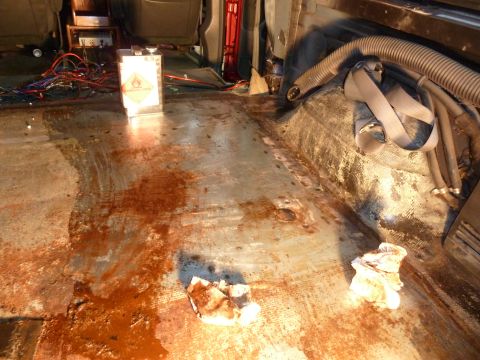 1993 Ford C-150 (Centurion Conversions) - Interior of a vehicle showing a messy floor with spilled liquid and exposed wiring.