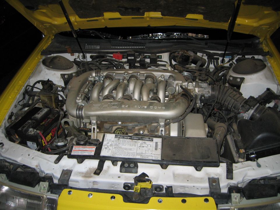 Ford SHO V6 engine with intake manifold visible. Battery and other engine components are also in view
