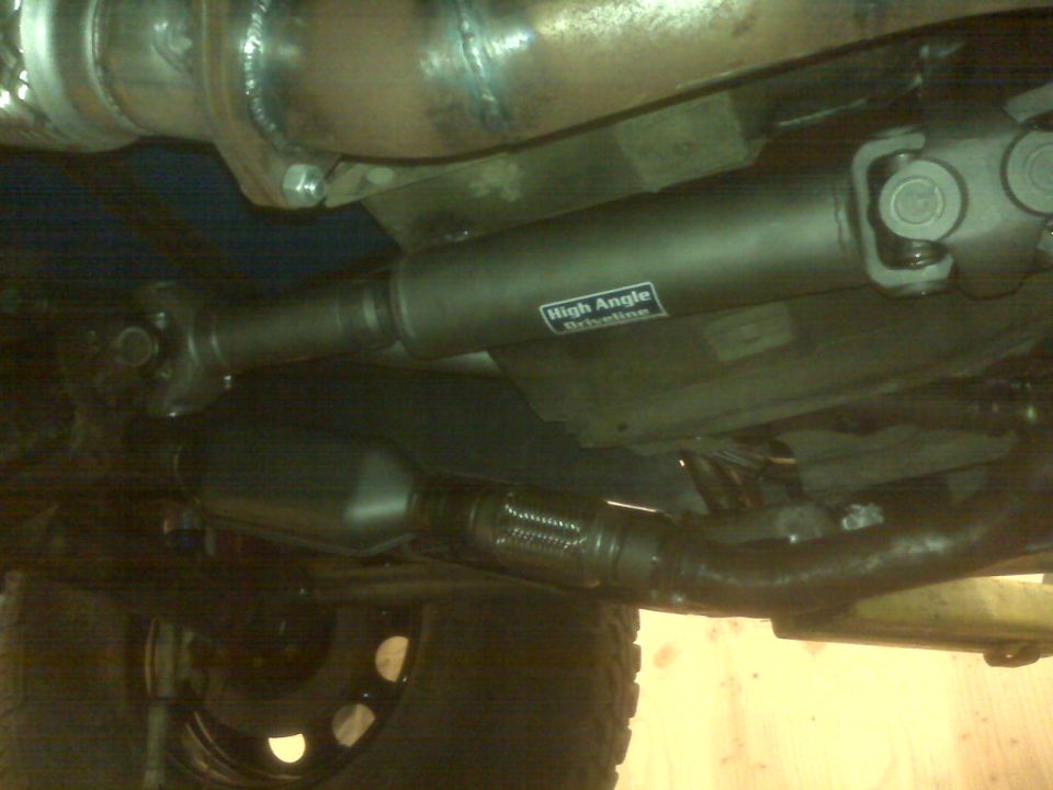 Driveshaft with 'High Angle Driveline' sticker and exhaust components visible underneath a vehicle