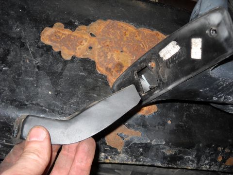 1993 Ford C-150 (Centurion Conversions) - A hand holds a detached door handle over a section of heavily rusted metal, likely from a vehicle's body.
