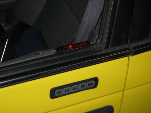 2002 Ford Taurus - A yellow car door is visible with a keypad entry system and a red indicator light above the window.