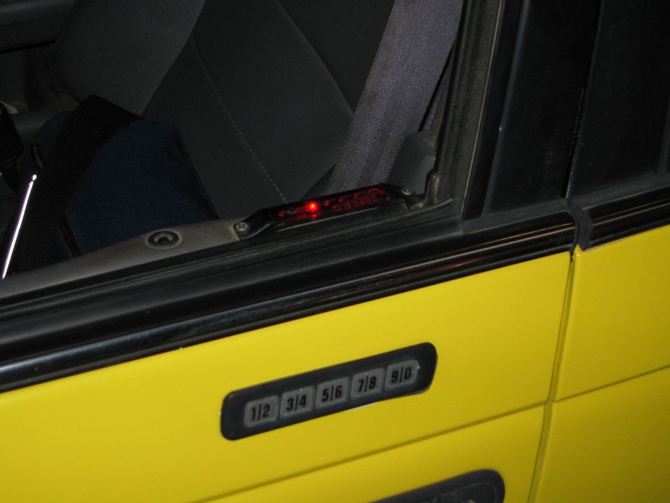 Yellow car door with a black keypad entry system and a red light above the window