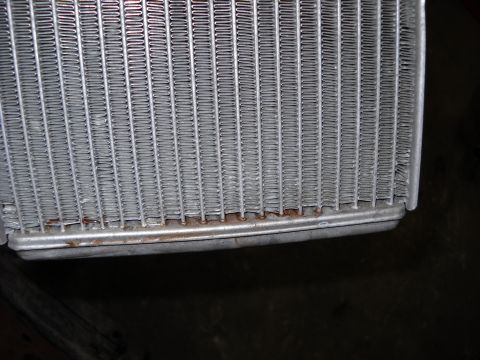 1993 Ford C-150 (Centurion Conversions) - Close-up view of a heater core, showing signs of corrosion along its lower edge.