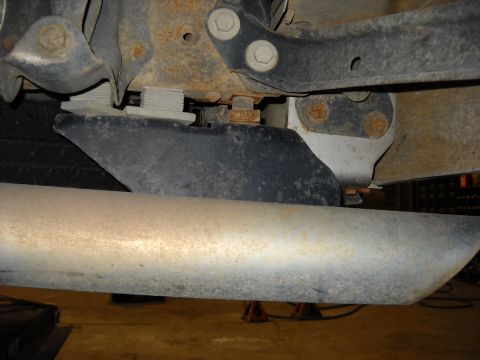 1993 Ford C-150 (Centurion Conversions) - Underside view of a vehicle's exhaust system and suspension parts, showing rust and wear.