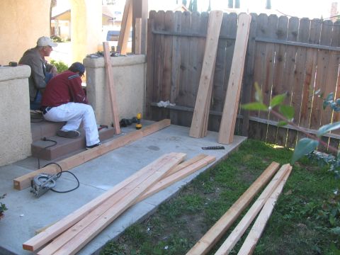 1968 Ford Mustang - Men are engaged in a construction project, surrounded by lumber and tools on a patio.