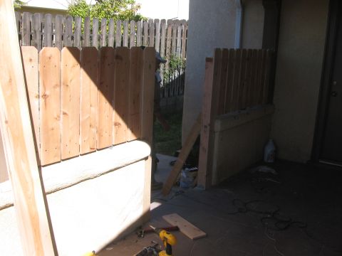 1968 Ford Mustang - Construction materials and a partially built fence on a patio area.