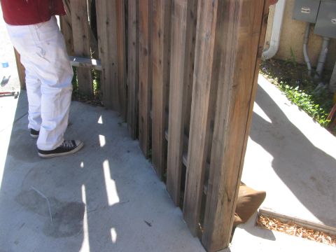 1968 Ford Mustang - A person is installing a wooden fence on a concrete walkway.