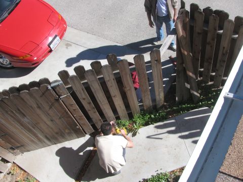 1968 Ford Mustang - A red sports car is visible from a high angle, parked near a damaged wooden fence.